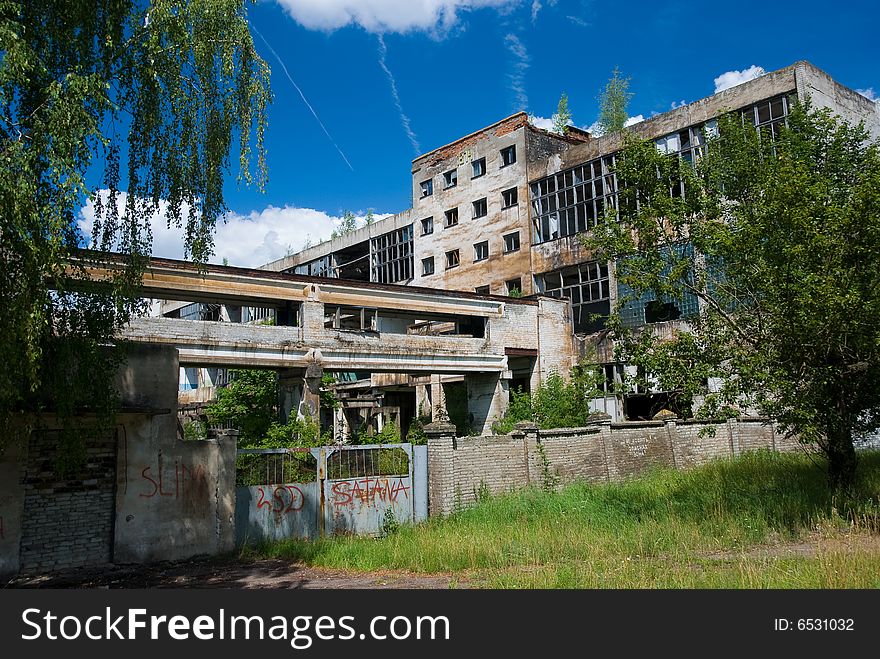 Abandoned chemical factory building with broken windows.