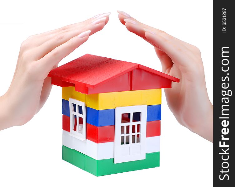 Hands of young woman protect toy colour plastic house with red roof. Hands of young woman protect toy colour plastic house with red roof