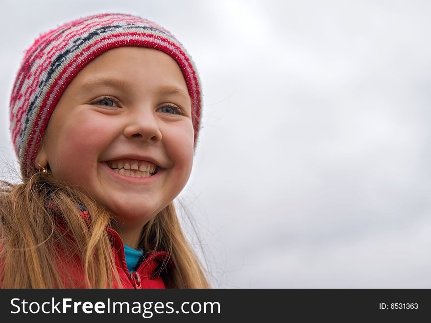 Young girl in a rose cap on a background sky. Young girl in a rose cap on a background sky