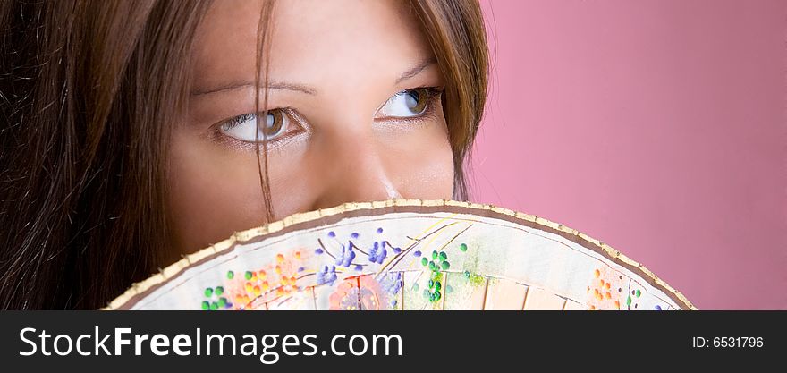 Beautiful brunette hold on a fan