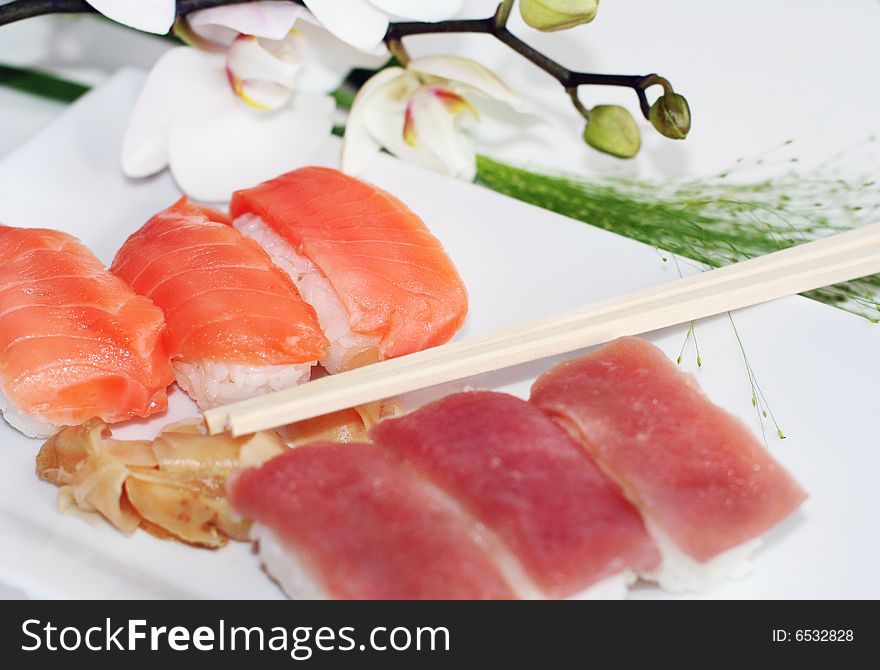 Salmon sushi plate with chopsticks and orchid