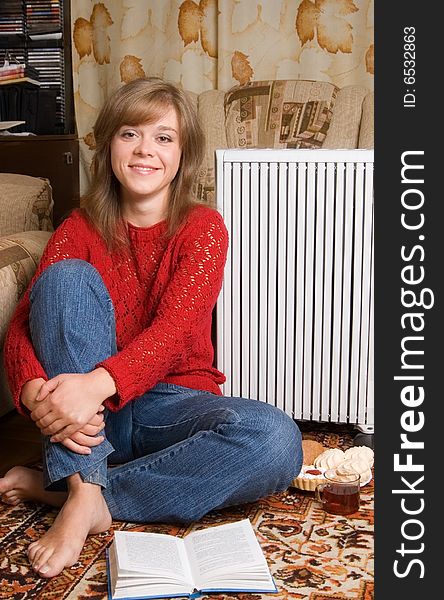 Woman sits on a carpet in a living room. Woman sits on a carpet in a living room