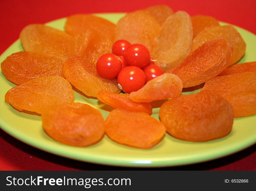 Plate of apricots with red berries in the middle. Plate of apricots with red berries in the middle