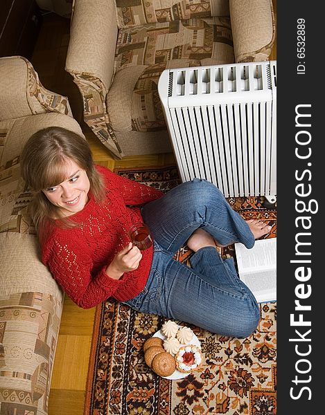 Woman sits on a carpet in a living room. Woman sits on a carpet in a living room