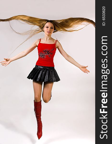 The beautiful girl with long hair jumps. The beautiful girl with long hair jumps
