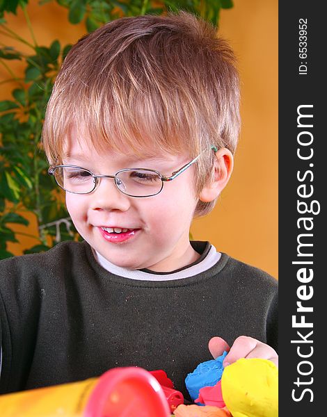 Young cute boy playing with plasticine. Young cute boy playing with plasticine