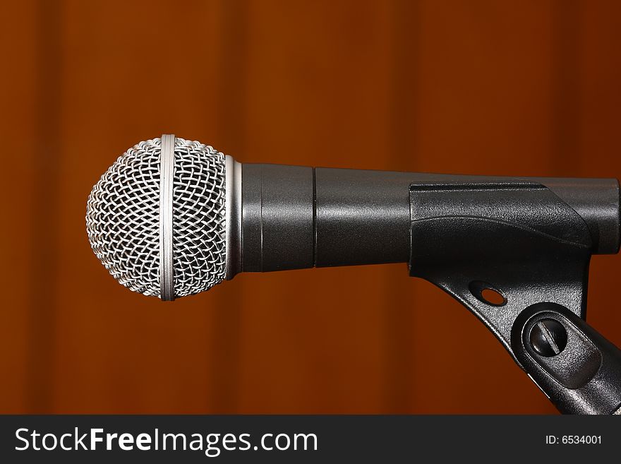 Silver-black studio microphone on rusty background