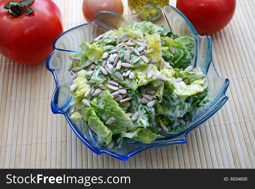 A fresh salad with sunflower seeds in a blue bowl