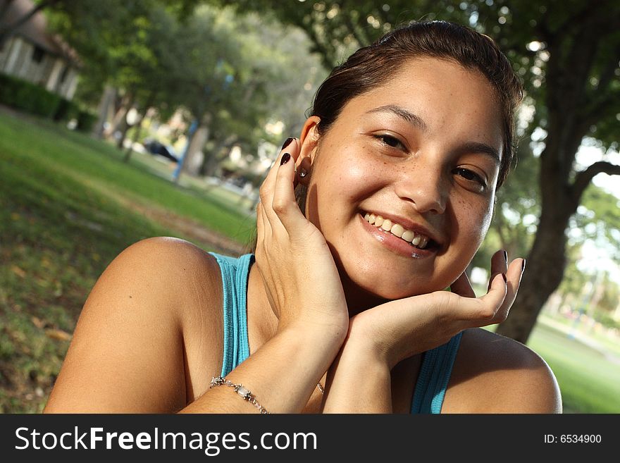 Young female smiling with her hands by her face. Young female smiling with her hands by her face