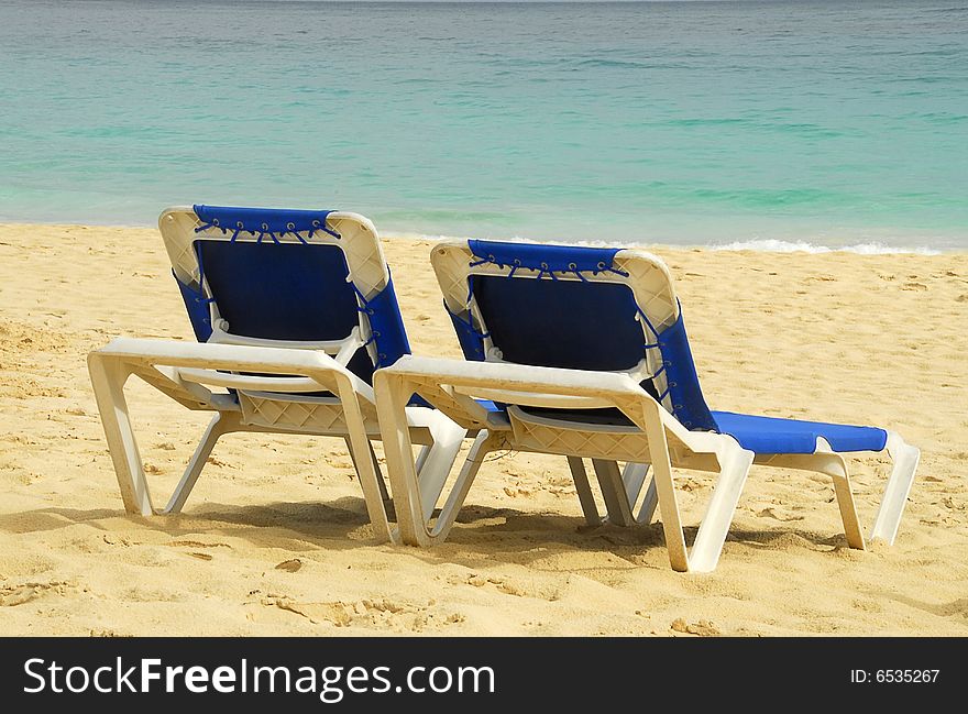 Two sun beach chairs on shore near Caribbean Sea, Beach Bavaro, Dominican Republic