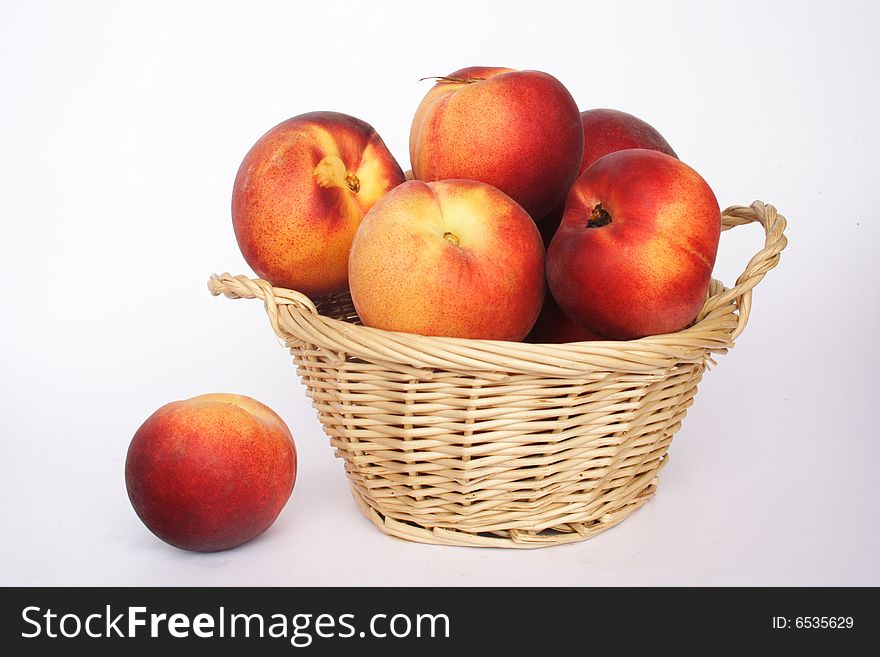 Fresh nectarines in a basket and white background. Fresh nectarines in a basket and white background