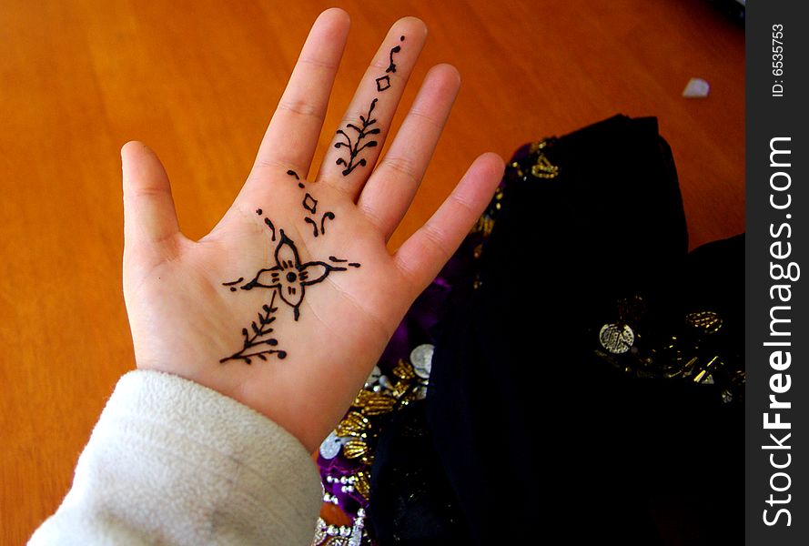 A woman's hand with freshly applied henna, and a bellydancing coin belt (Australia). A woman's hand with freshly applied henna, and a bellydancing coin belt (Australia).