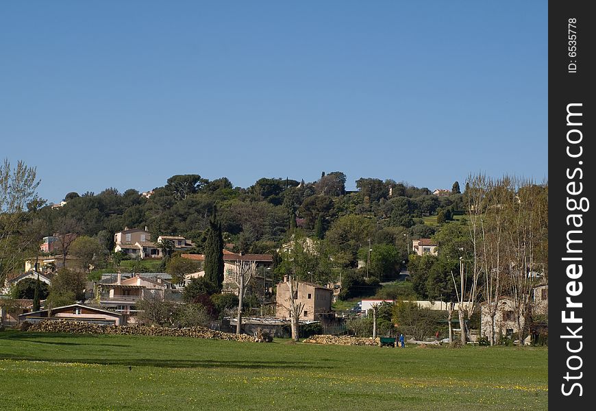 A village on a hill with a field in the foreground