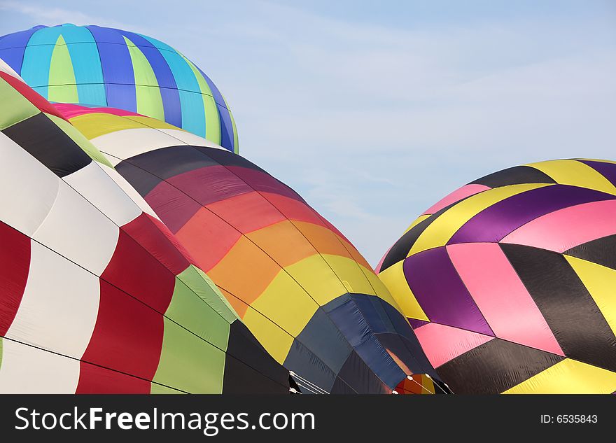 Closeup of multi-colored hot air balloons being inflated