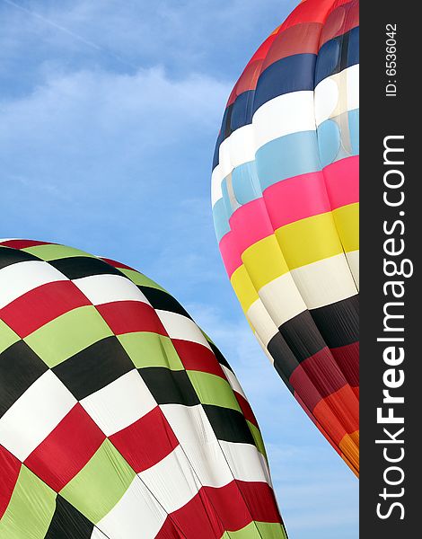 Multi-colored hot air balloons ascending into the clear blue sky