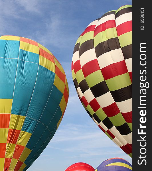 Multi-colored hot air balloons ascending into the clear blue sky