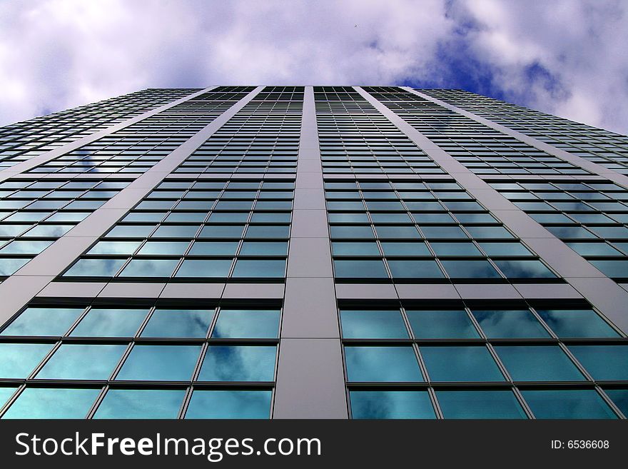 The could reflect of a glass covered skyscraper in Tokyo, Japan