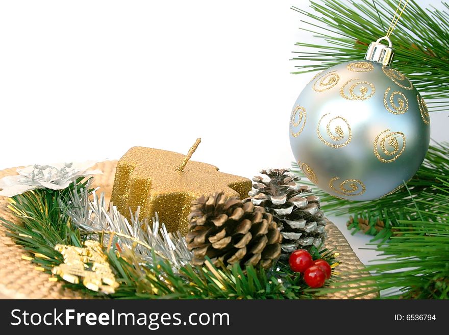 Christmas gray ball on the fir-tree and golden dish with holly-berry,cones,candle.