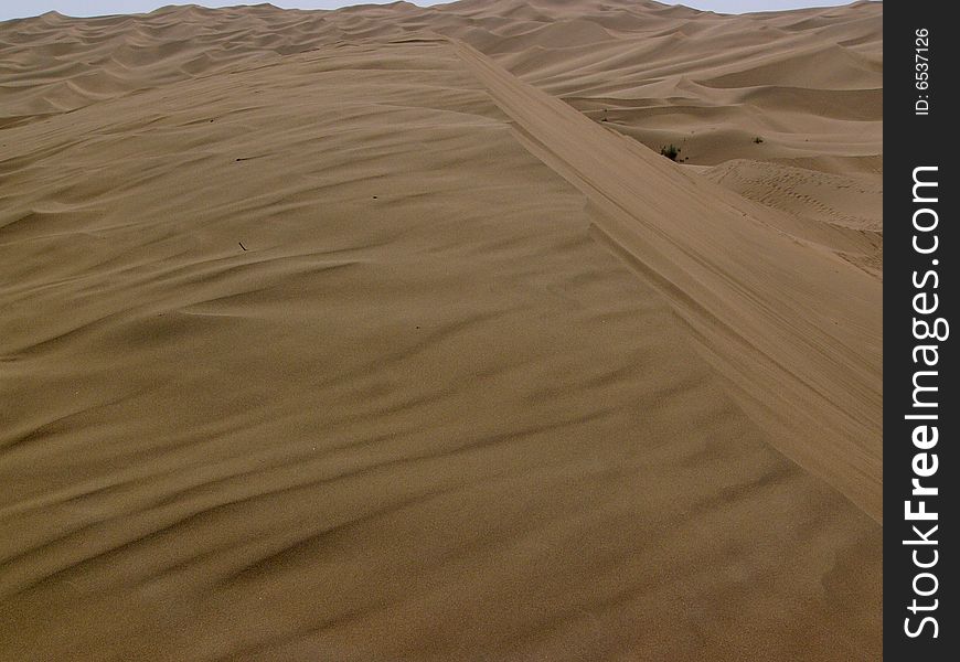 The sand of the dune flowing by wind and shaping a beautiful picture, in Kumutage desert. The sand of the dune flowing by wind and shaping a beautiful picture, in Kumutage desert.