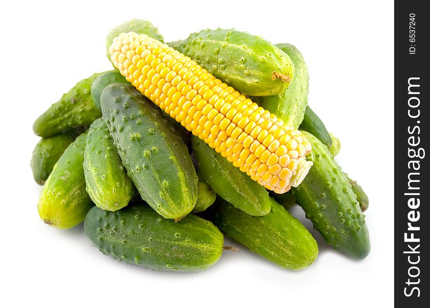 Vegetables corn yellow ear and green ripe cucumbers on white background
