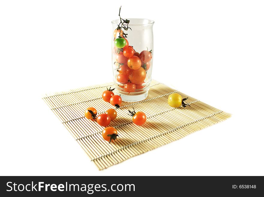 Tomatoes inside glass on bamboo mat. Tomatoes inside glass on bamboo mat