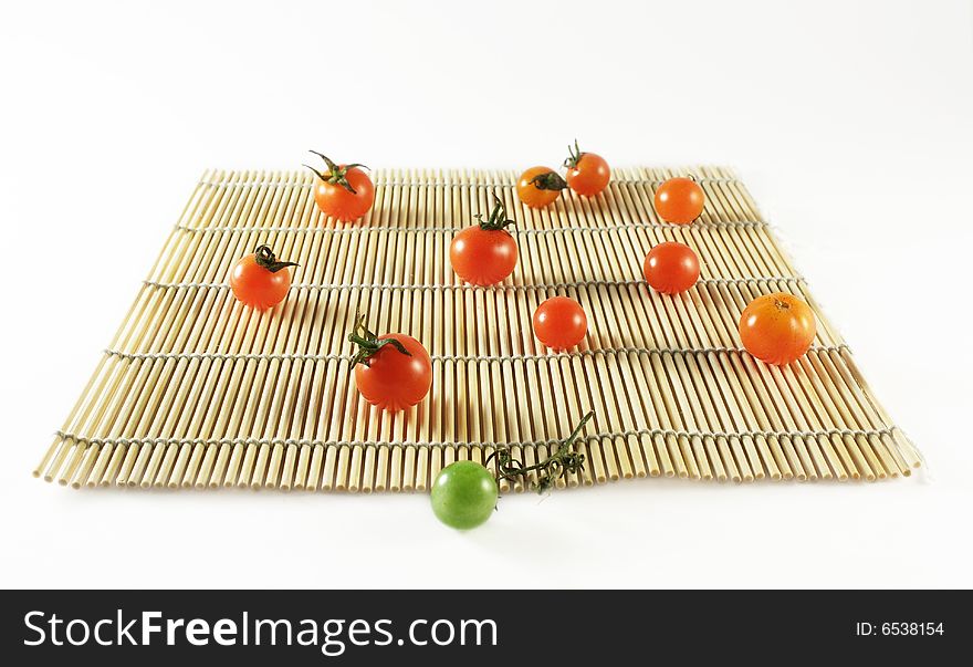 Tomatoes of grade cherry on bamboo mat. Tomatoes of grade cherry on bamboo mat