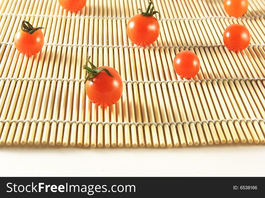 Tomatoes of grade cherry on bamboo mat. Tomatoes of grade cherry on bamboo mat