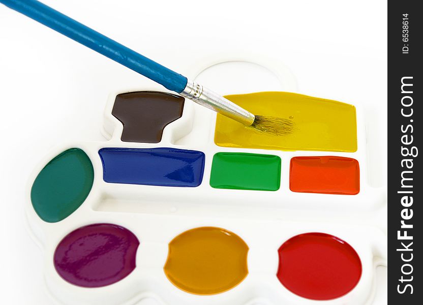 Box of watercolors and a brush isolated on a white background.