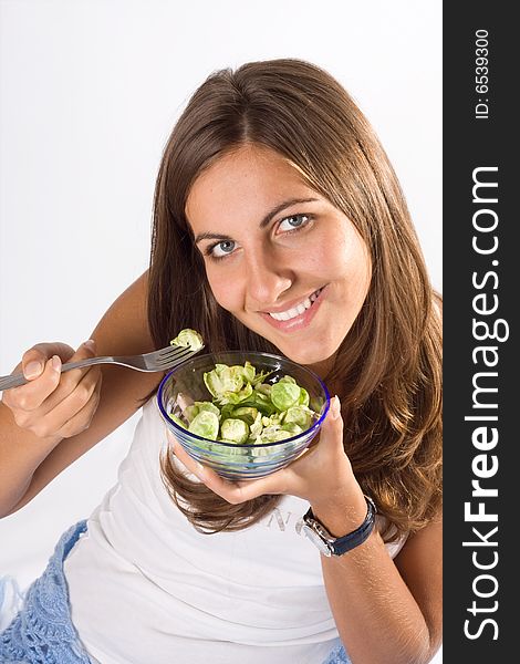 Portrait of young happy smiling woman eating salad