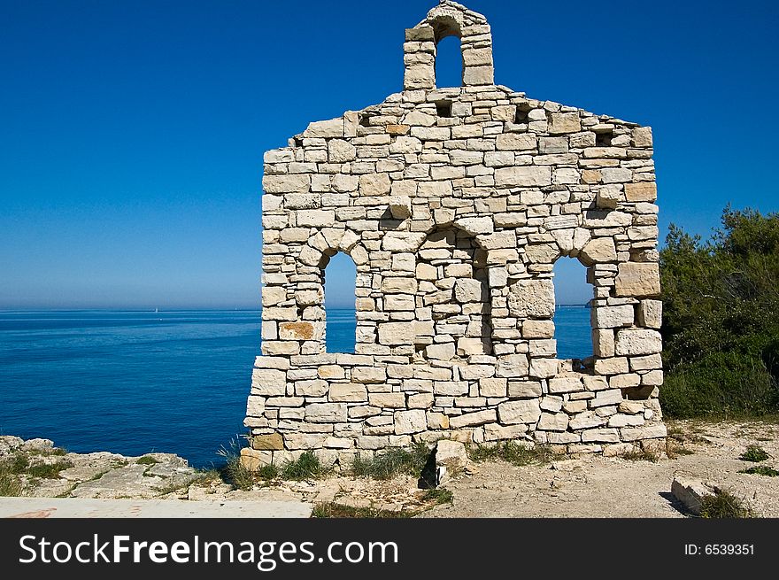 Photo of a fragment of ancient Roman wall at the coast of the Mediterranean sea, Croatia.