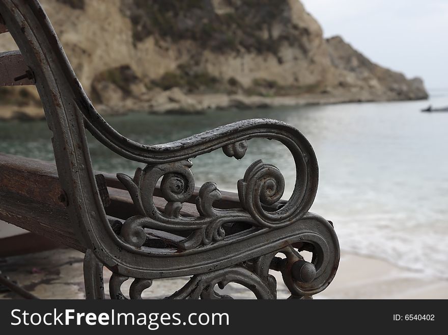 Fragment of the wet beach bench early in the morning.