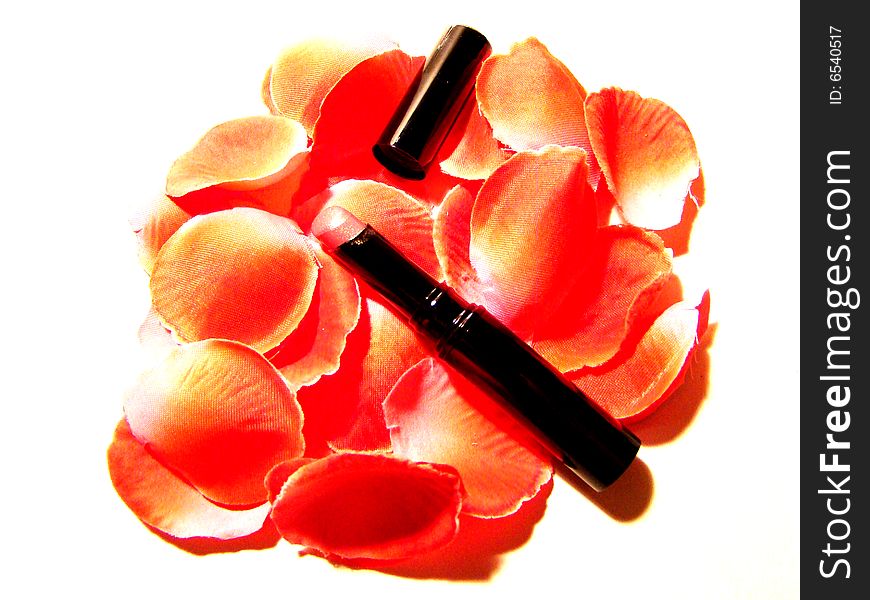 A still-life made of a lipstick and petals. A still-life made of a lipstick and petals