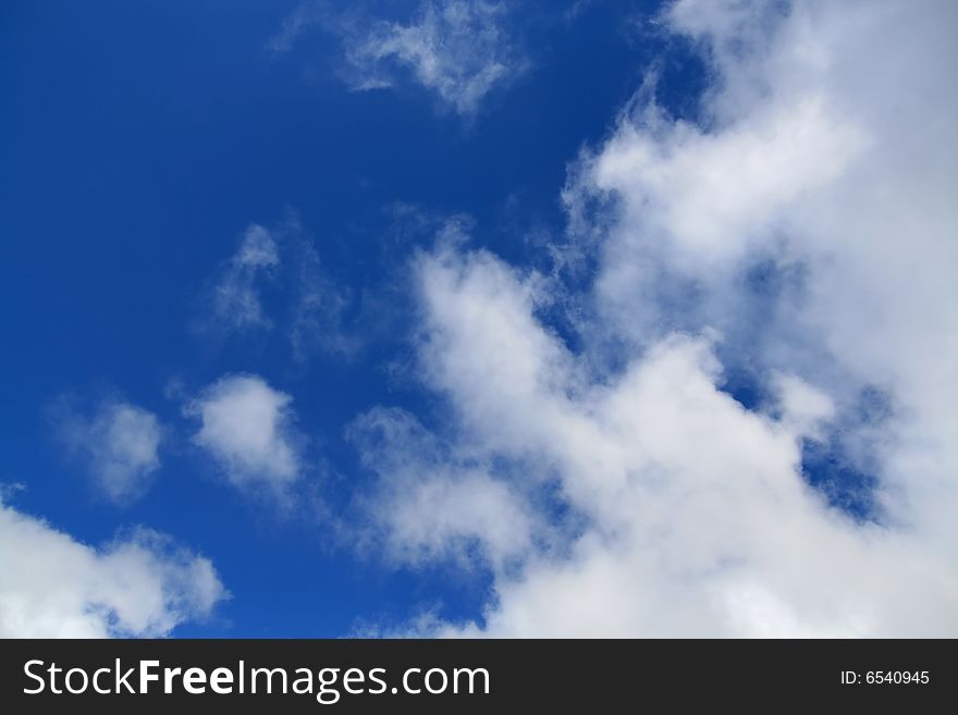 A cloudy sky with white wispy clouds and blue sky for use as background