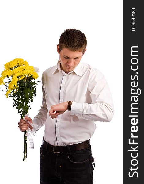 The man in a white shirt with a bouquet yellow flowers waits the girlfriend and looks at the watch. The man in a white shirt with a bouquet yellow flowers waits the girlfriend and looks at the watch