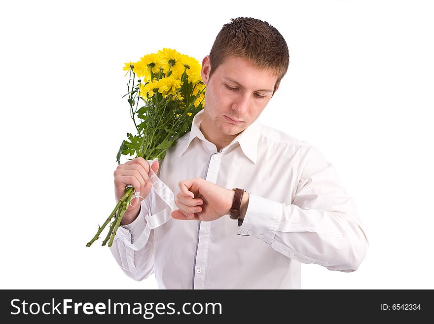 The man in a white shirt with a bouquet yellow flowers waits the girlfriend and looks at the watch. The man in a white shirt with a bouquet yellow flowers waits the girlfriend and looks at the watch