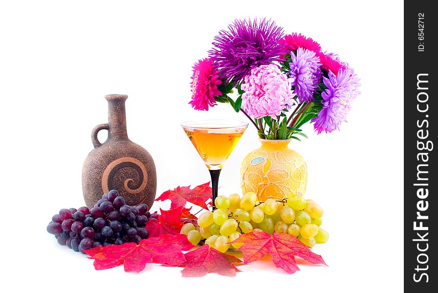 Autumn maple red leaves and ripe grapes with wine on white background