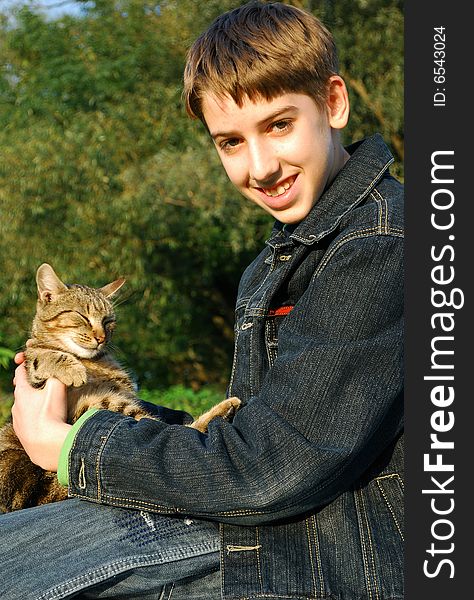 Boy playing with a cat outdoors. Boy playing with a cat outdoors