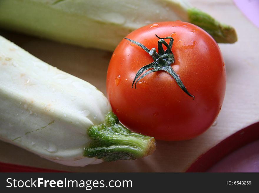 Red tomato and two vegetable marrows. Red tomato and two vegetable marrows