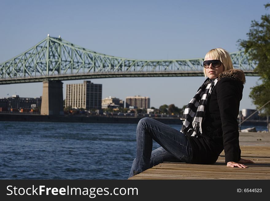 Woman In Jacket Sitting On Dock