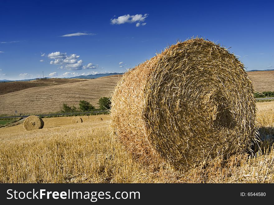 Chianti summer landscape with hay bales and blue cloudy sky. Chianti summer landscape with hay bales and blue cloudy sky