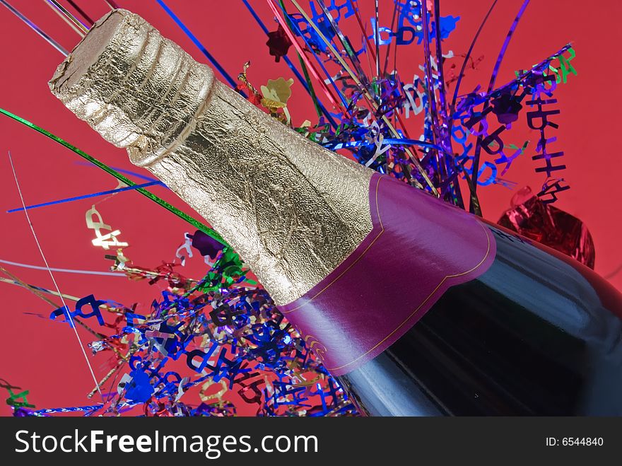 Champagne bottle with colored confetti behind. Champagne bottle with colored confetti behind