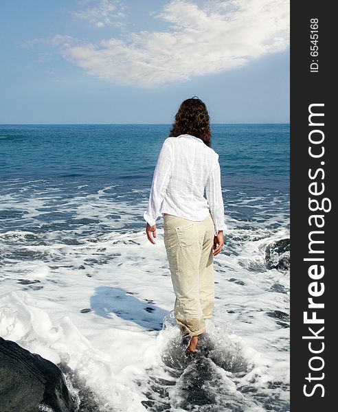 Woman standing on a black sand beach on Big Island, Hawaii. Woman standing on a black sand beach on Big Island, Hawaii