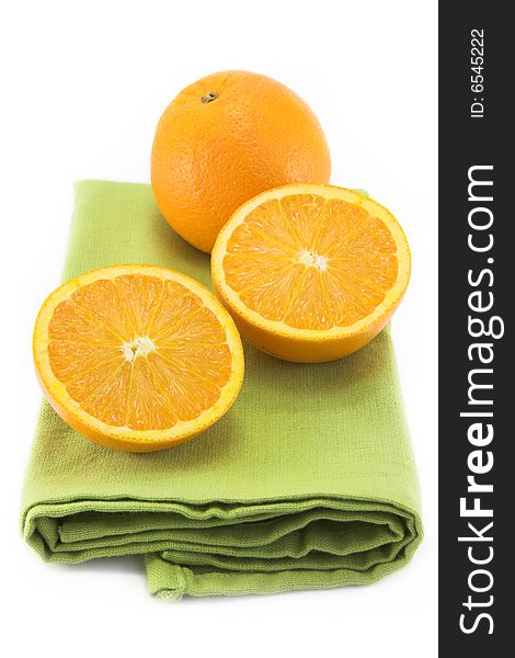 Oranges on a green folded cloth placemat, isolated on white. Oranges on a green folded cloth placemat, isolated on white.