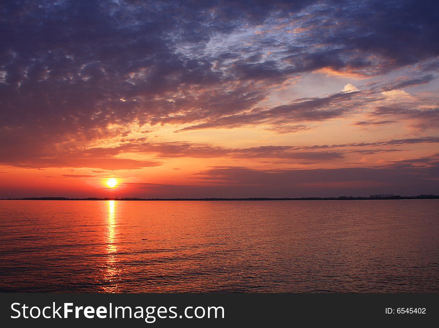 The sun sets over Lake Ontario illuminating the sky in a spray of color. The sun sets over Lake Ontario illuminating the sky in a spray of color.