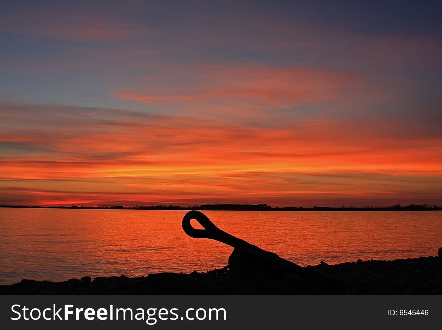 An abandoned anchor sits on the cold rocks bordering Lake Ontario. An abandoned anchor sits on the cold rocks bordering Lake Ontario.
