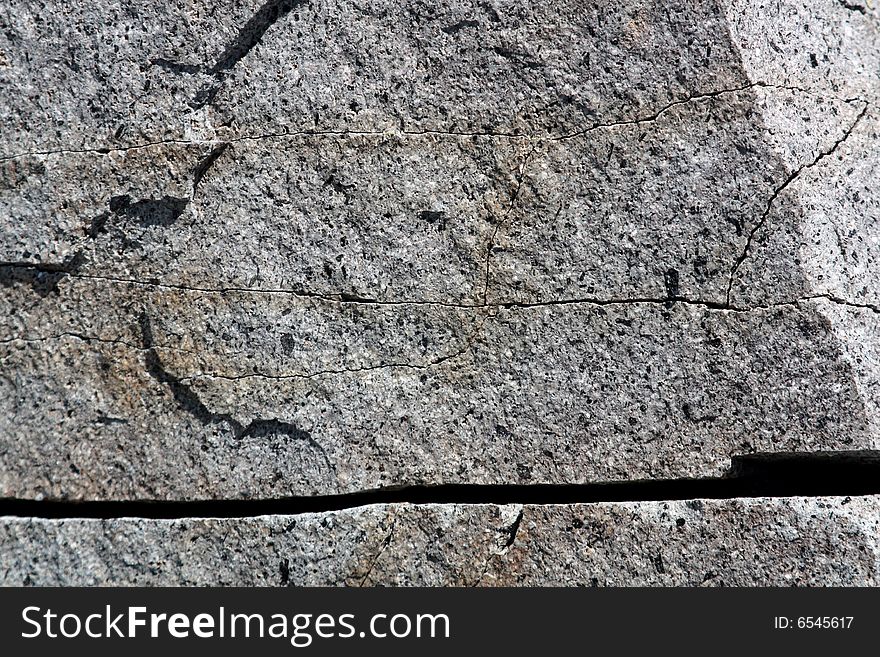 A cracked and worn rock face with deep rivet. A cracked and worn rock face with deep rivet.