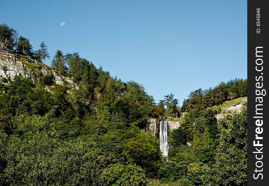 Overview of Pistyl Rhaeadr Waterfall near Llanrhaeadr in Wales with moon in the sky. Overview of Pistyl Rhaeadr Waterfall near Llanrhaeadr in Wales with moon in the sky