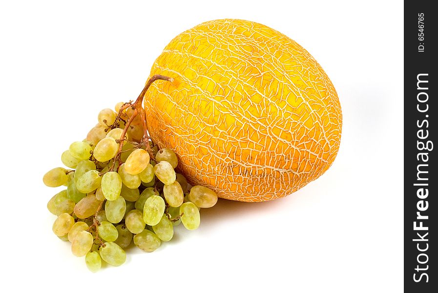 Fragrant yellow sweet melon and ripe green grapes on white background