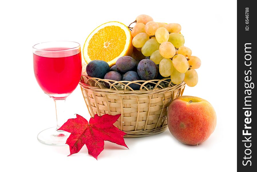 Red wine in wine-glass and ripe beautiful fruit peach plums grapes orange in basket on white background