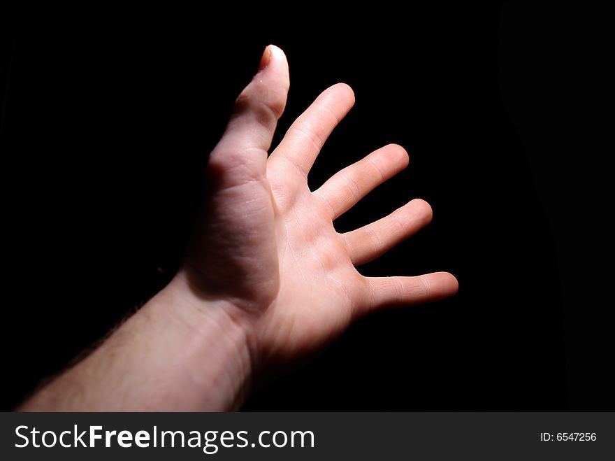 Extended hand for help on a black background